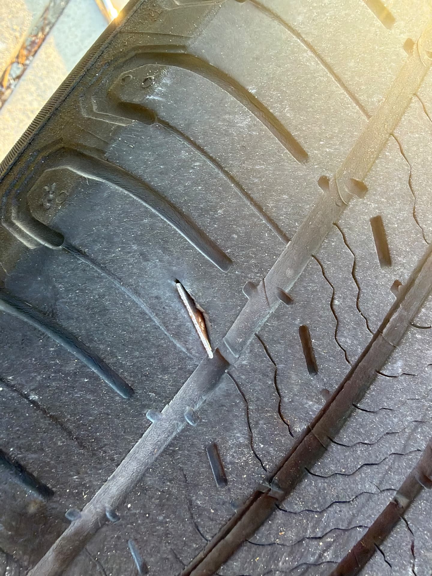 Tire puncture inspection in Denton, TX 76201 Close view of a metal object embedded in tire tread during a roadside puncture inspection in Denton, Texas 76201