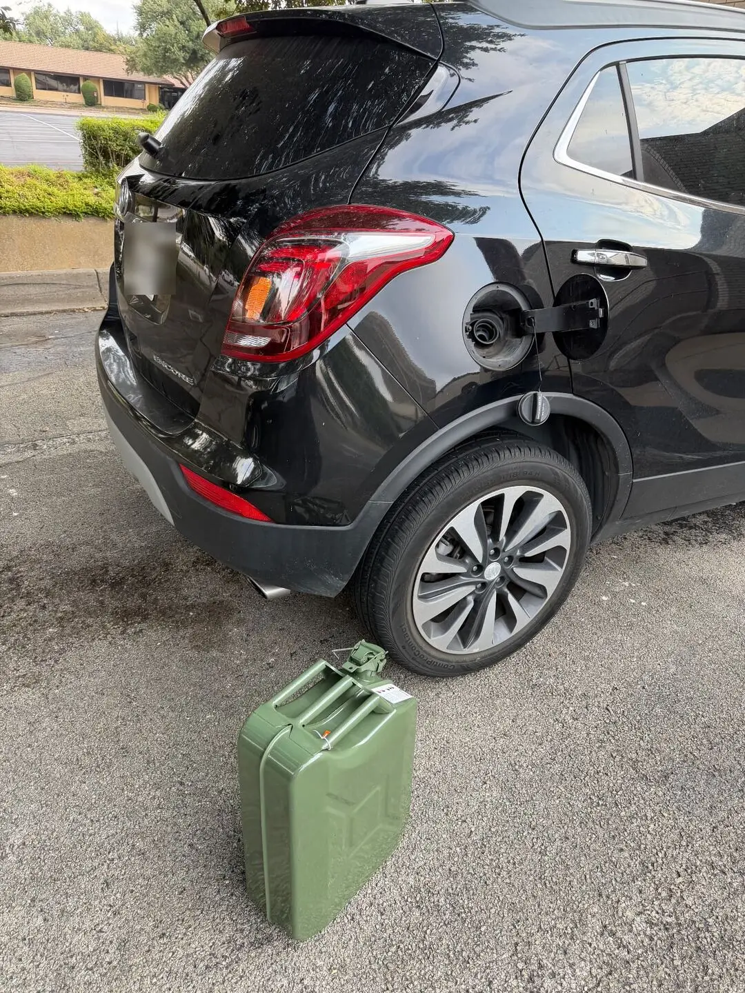 Emergency fuel delivery in Dallas–Fort Worth — fuel brought to the vehicle Fuel can staged at the open fuel filler door of a black Buick Encore SUV during an emergency fuel delivery call in Dallas, Texas
