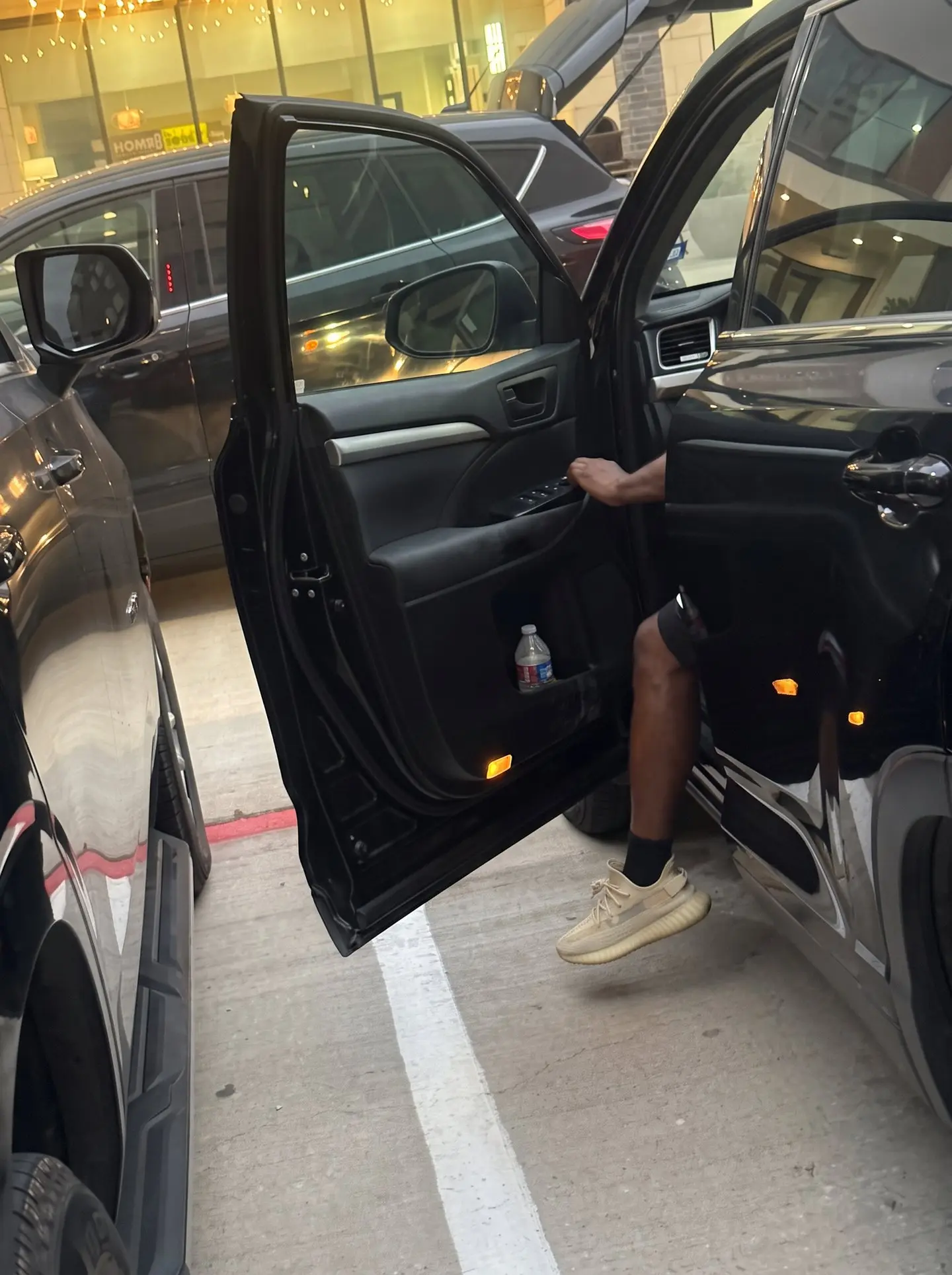 Toyota Highlander with the driver door opened after a late-night car lockout in a McKinney parking lot, driver seated back inside the vehicle